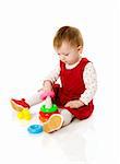 Toddler girl playing with toys isolated on white