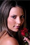 Beautiful young brunette woman holding a red rose a sign of love for valentines or any other special occasion