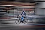 Bicycle woman rushing on the street in motion blur, side view  from Copenhagen, Denmark.
