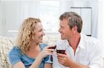 Couple drinking some red wine in the living room at home
