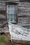 Old wooden boat and clapboard house, Canada