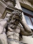 Sculpture of a man resembling Atlas holding up the corner of a building. Prague, Czech Republic