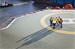 Workers talking on helipad of oil rig