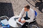 Businessman using laptop at cafe