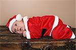 Beautiful six week old baby boy wearing a Christmas suit