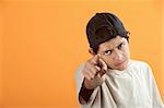 Serious or angry Latino kid points index finger