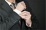 Close-up of a businesman adjusting his cufflink.