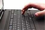 Close-up of finger over black laptop keys going to press enter button