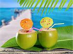 coconuts straw cocktails in tropical caribbean sea pier with boat