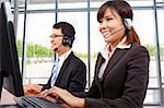 Smiling customer service representative in modern office with a headset