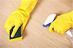 A picture of hands in yellow gloves cleaning the floor