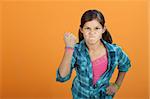 Brave angry little Latino kid on an orange background