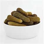 Gherkin pickles in a porcelain bowl, isolated over white background.