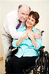 Loving, supportive husband gives his disabled wife a hug.