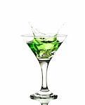 green martini cocktail splashing into glass on white background