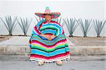 Mexican man sit sombrero serape and agave cactus smiling