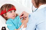 Woman doctor examines sick little beautiful girl