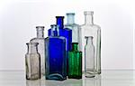 Group of vintage medicine bottles, green, blue and colourless glass; differential focus