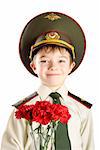 Close-up portrait of young boy in Ministry of Defense cap and military uniform with red flowers. Image isolated on pure white background