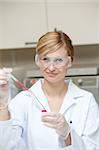 Close-up of a female scientist putting liquid in a test tube with a pipette in her laboratory