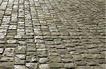 Part of urban square covered with cobblestone. Sunlight reflected on the stones