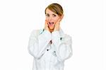 Surprised medical doctor woman holding her hands near face  isolated on white