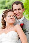 wedding couple is standing at sunny park