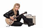 Blond rock teenage girl playing an electric guitar on her knees. Studio shot, isolated on white background.