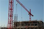 Construction site with red cranes and building