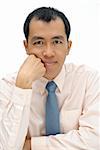 Mature executive of Asian considering and thinking and looking at you, half length closeup portrait on white background.