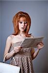 Portrait of red-haired girl with newspaper. 60s style.