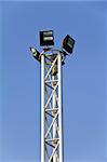 Spotlight pole over the blue sky.