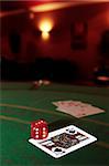 green casino table with dice on a jack of spades and a royal flush