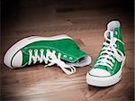 Retro green sneakers left on wooden floor grungy effects