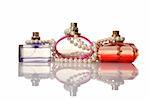 Perfume in a glass bottles and pearl beeds on white background