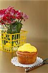 cupcake with yellow cream on a wooden table