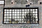 Concrete wall and view from broken window of abandoned factory.