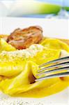 Ravioli served with meat with fork in the foreground (Selective Focus)