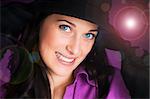 Portrait of a beautiful brunette young woman smiling with black hat and gloves