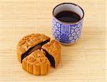 Chinese mooncake and tea cup on bamboo mat