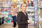 Closeup of a young woman smiling while shopping in the supermarket