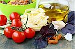 Italian Pasta with tomatoes, olive oil and basil on wooden background