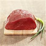fresh raw meat on wooden cutting board