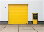 small industrial warehouse with a single yellow roller door