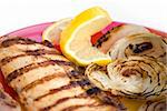 Grilled chicken breasts with onion and lemon in a plate