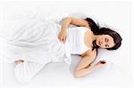 Stock image of young woman sleeping on white bed