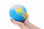 Young boy's hand holding completed globe jigsaw puzzle on white background