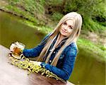 A young blue-eyed blonde enjoys her beer.