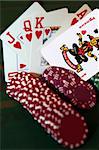green casino table with chips and a hand of a royal flush in a poker game and a joker in the pack