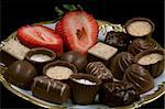 pralines decorated with a strawberry on a plate